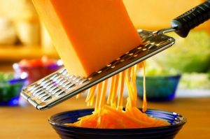 30 Jul 2004 --- Cheddar being grated with a coarse grater --- Image by © Johns, Douglas/the food passionates/Corbis